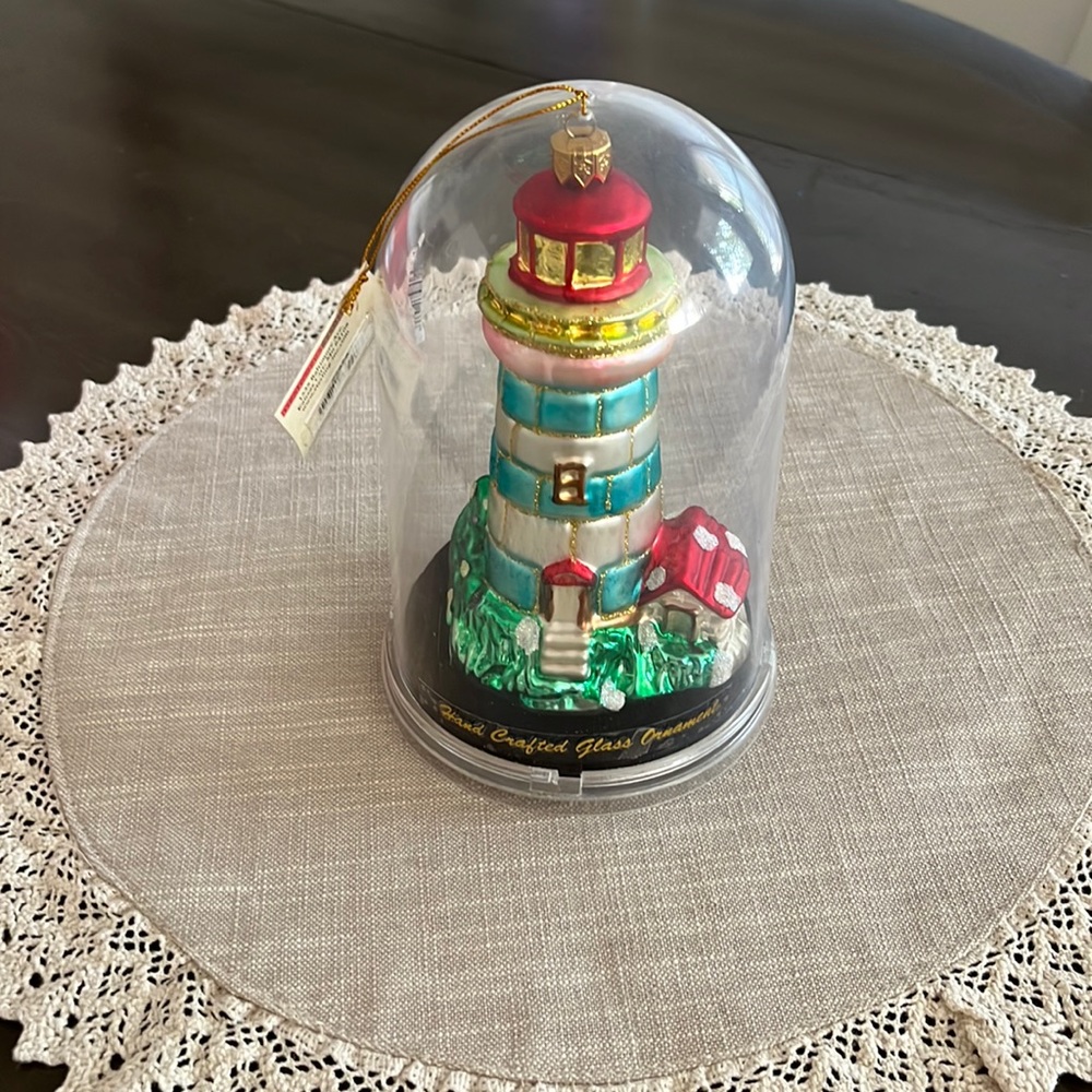 Handcrafted glass lighthouse ornament.
